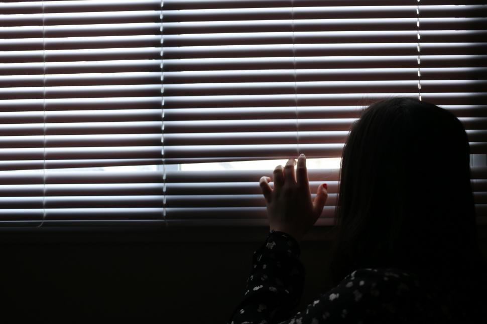 Free Image of A girl peaking outside the window 