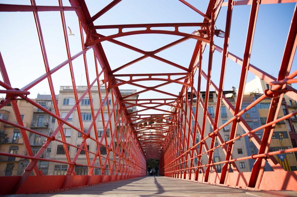 Free Image of A red caged-design walking bridge 