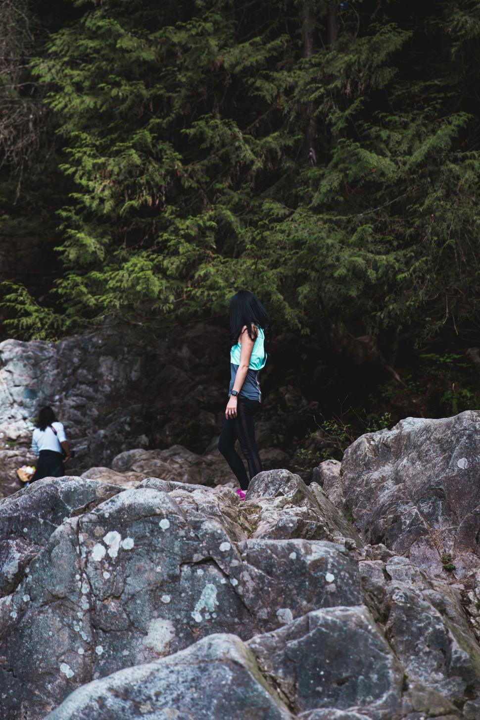 Free Image of A young female hiker standing on a rock 