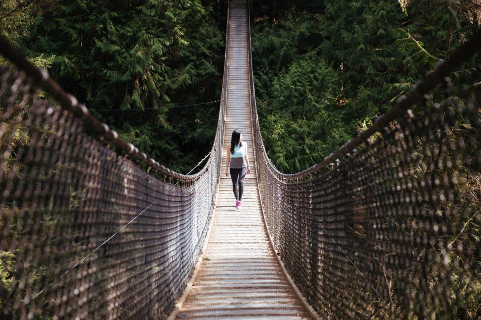 Free Image of A young Asian woman walking on the bridge 