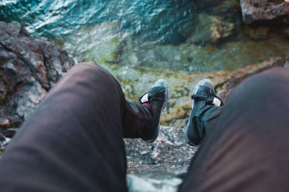 Free Image of Feet hanging over the edge of a rock 