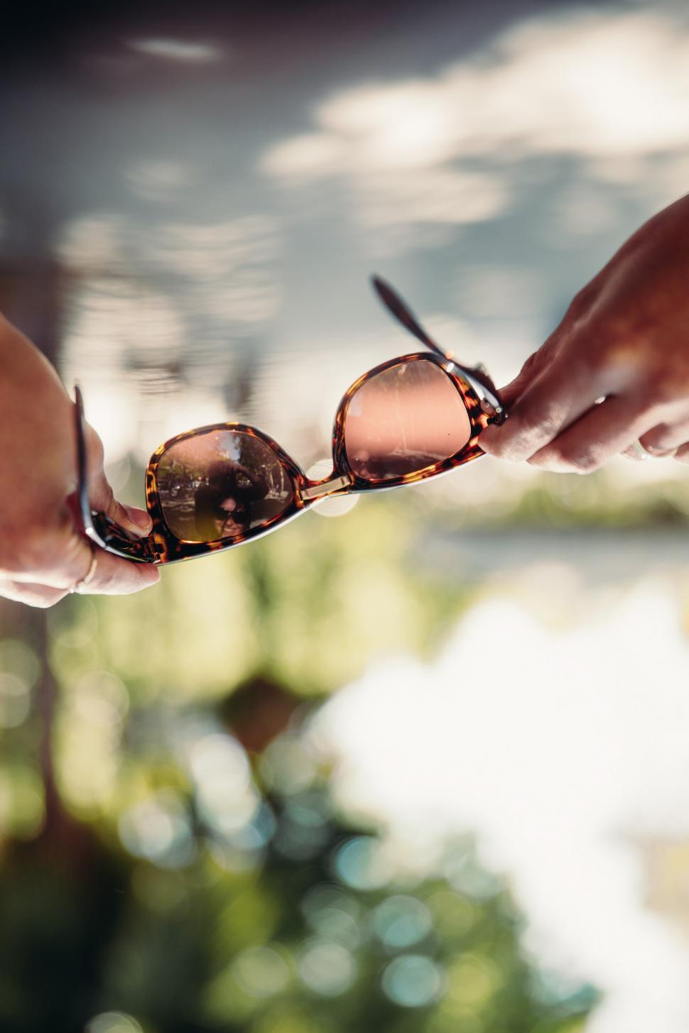 Free Image of Sunglasses held by female hands 