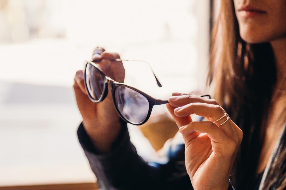 Free Image of A young caucasian woman trying on sunglasses 