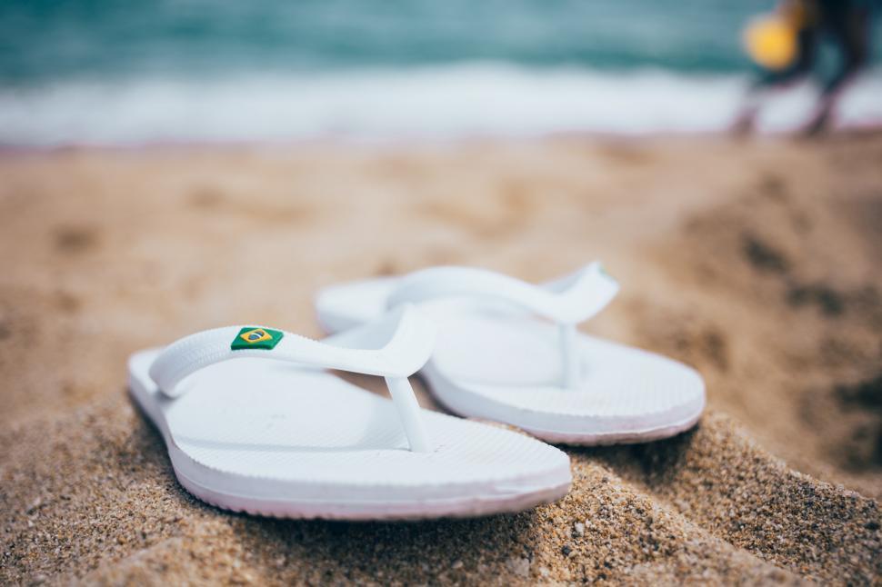 Free Image of White slippers on sand on the beach 