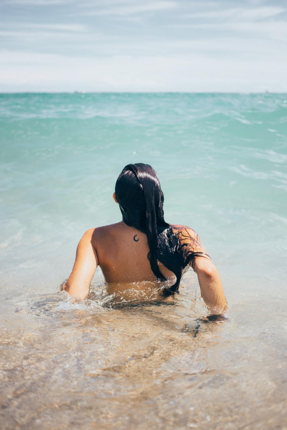 Free Image of A young caucasian woman swims in the ocean 