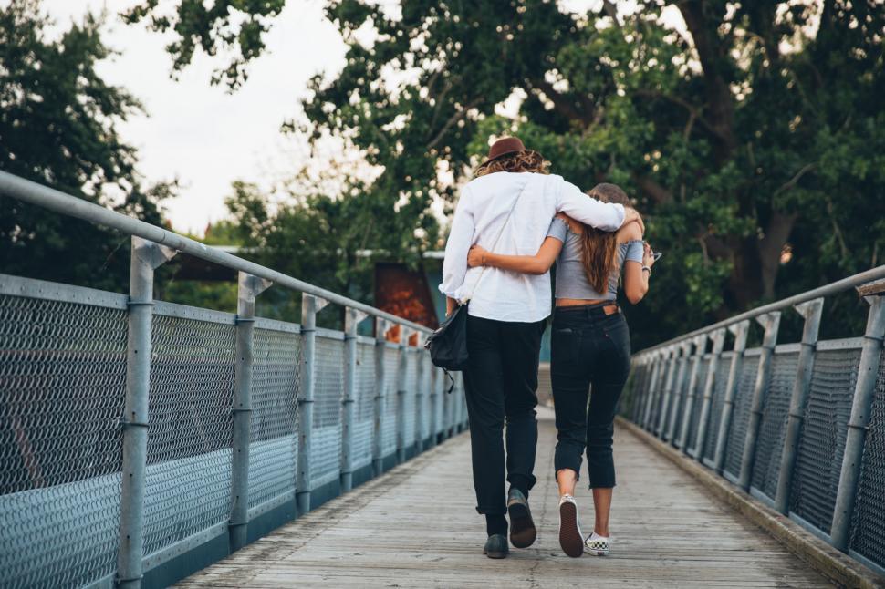 Free Image of A young caucasian couple walking on a bridge 