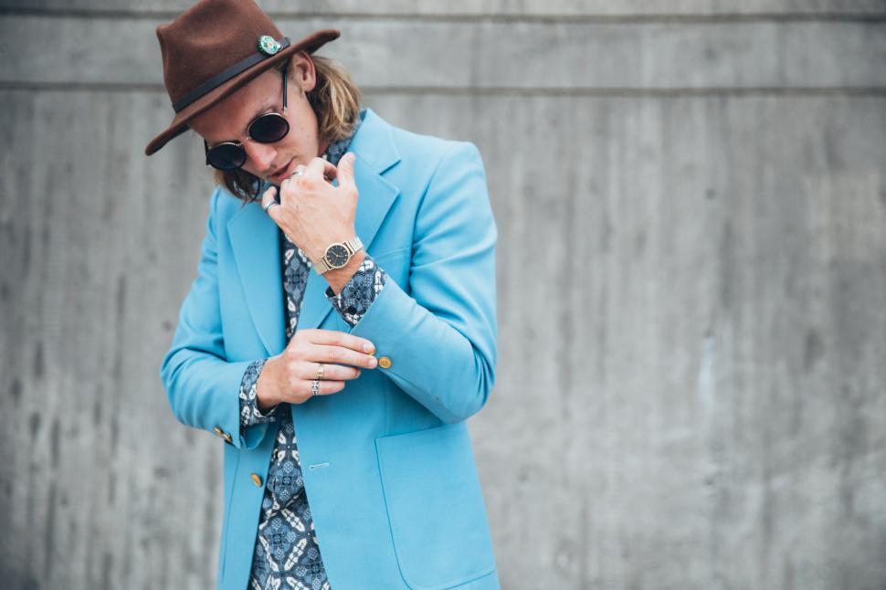 Free Image of A young Caucasian man wearing turquoise blue jacket posing outdo 