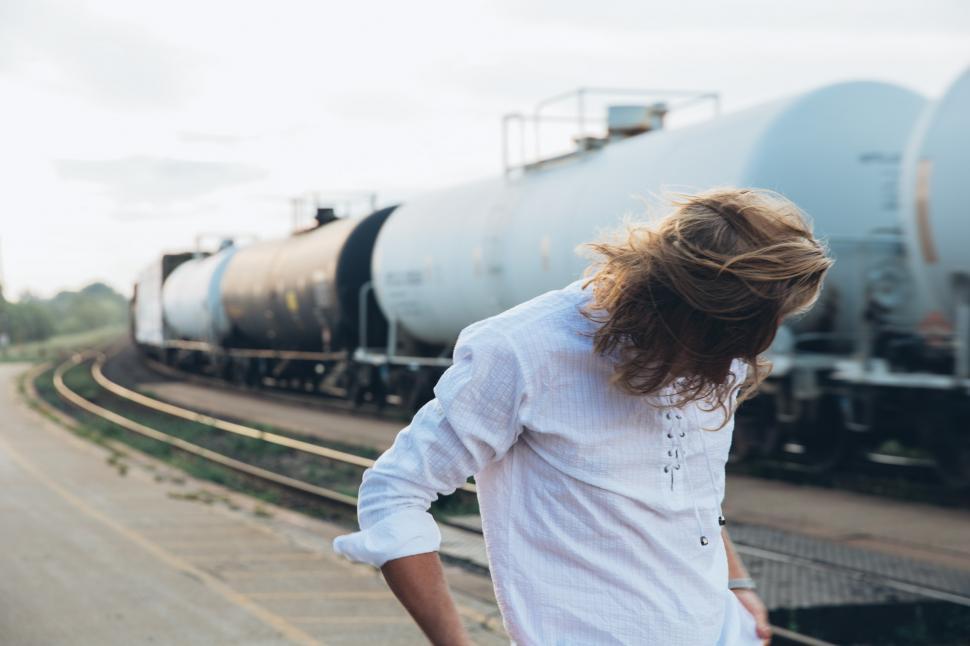 Free Image of A young caucasian man standing near passing train 