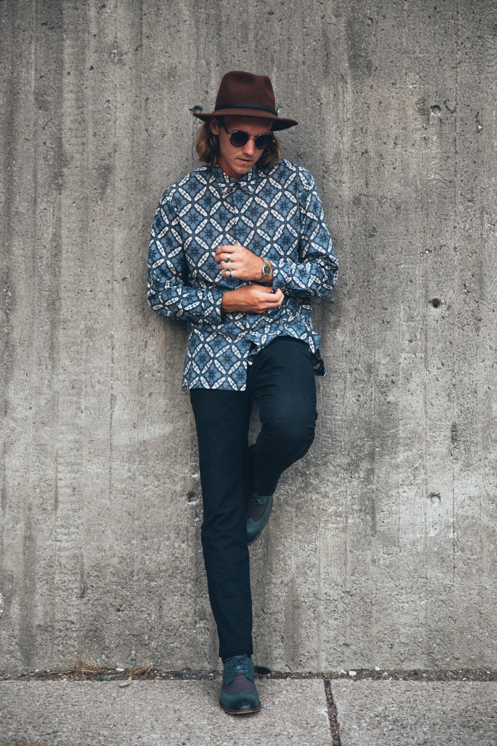 Free Image of A young man wearing patterned shirt posing outdoors 