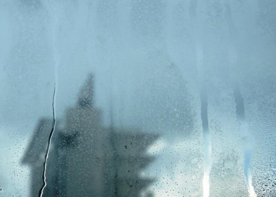 Free Image of Urban abstract background of a tower block seen through a misted window with raindrops  