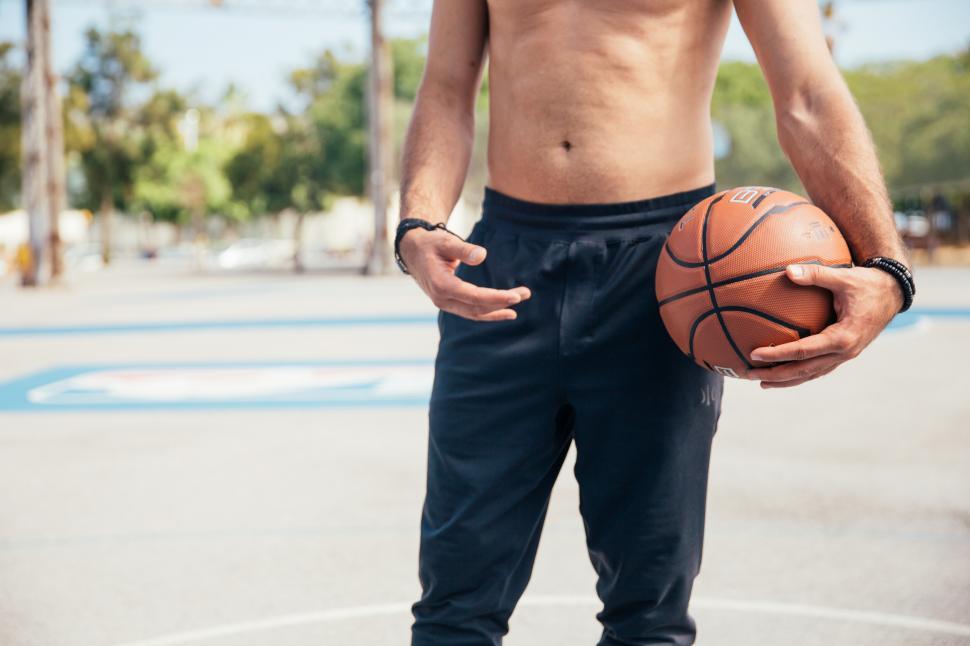 Free Image of A young man holding a basketball in his hand 
