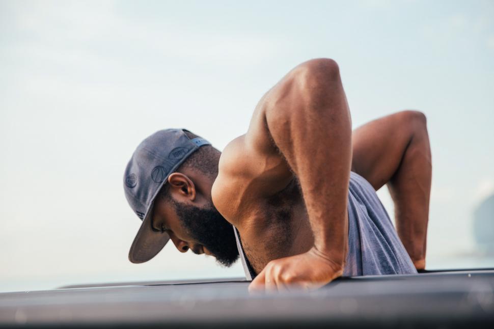 Free Image of A bearded young African man exercising on workout bars 