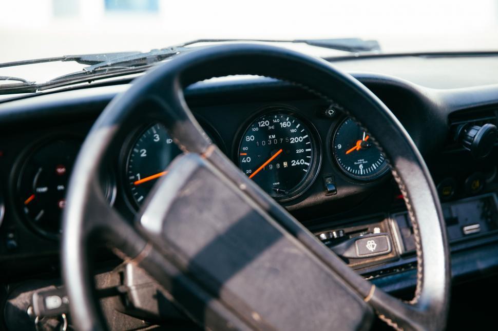 Free Image of Side view of interior of a car with speedometer in the backgroun 