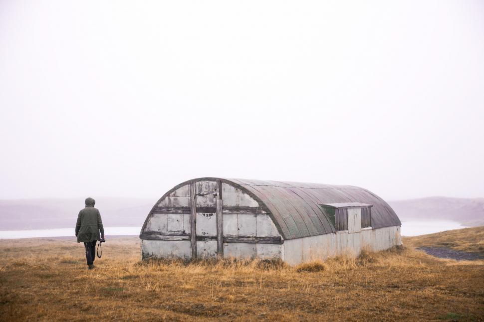 Free Image of An abandoned quonset and a hiker 