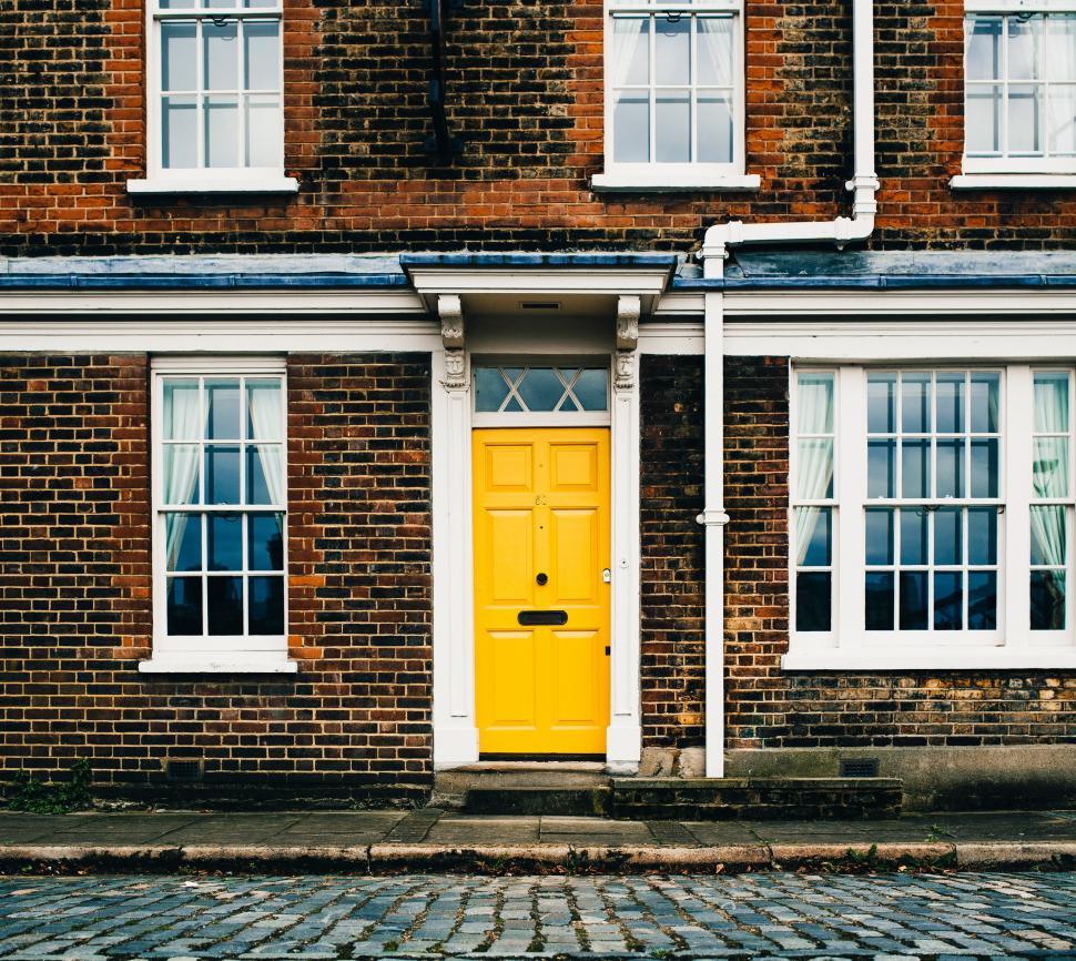 Free Image of Yellow entrance door on a brick home 