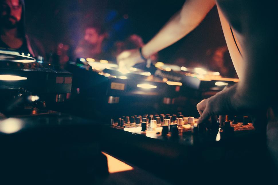 Free Image of A DJ operating a music mixing console 