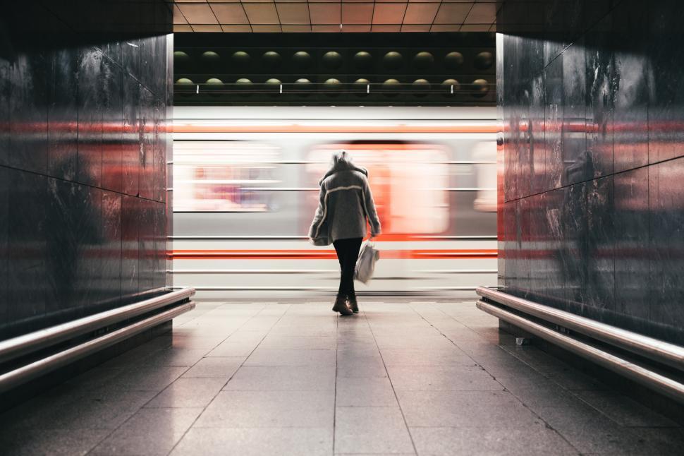 Free Image of A woman in hooded jacket waits for the train 