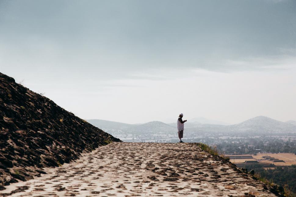 Free Image of A man standing on the edge of stone temple 