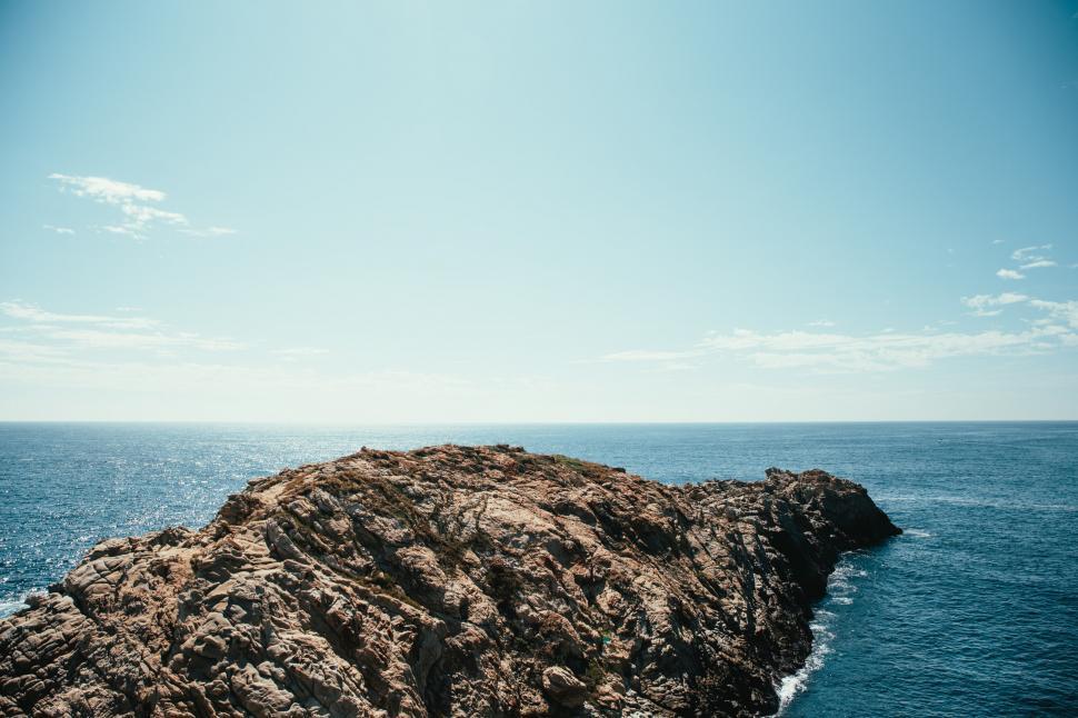 Free Image of A rocky cliff in the ocean 