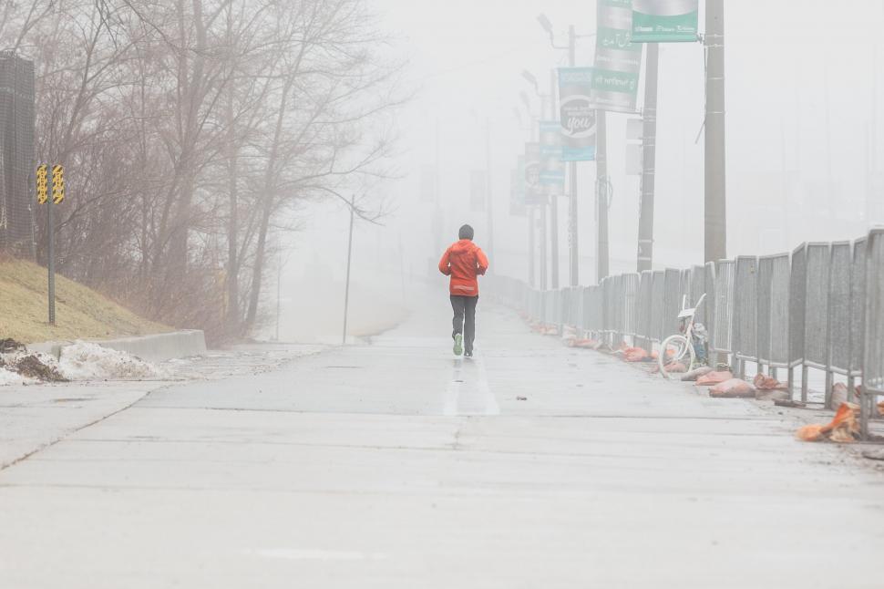 Free Image of Back view of a person jogging on a foggy day 