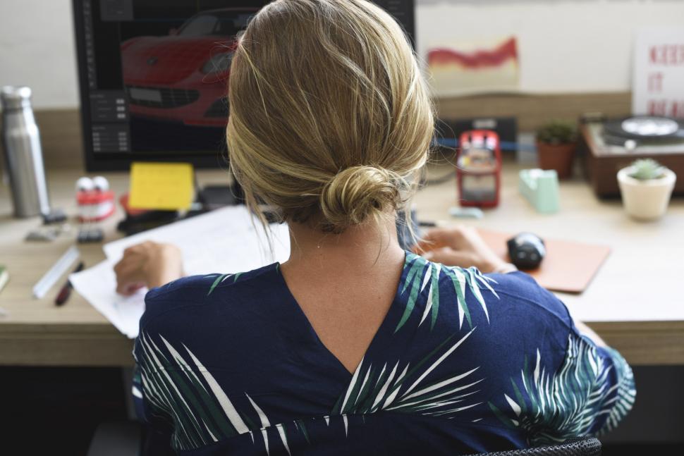 Free Image of Rear view of a blonde woman working at her desk 