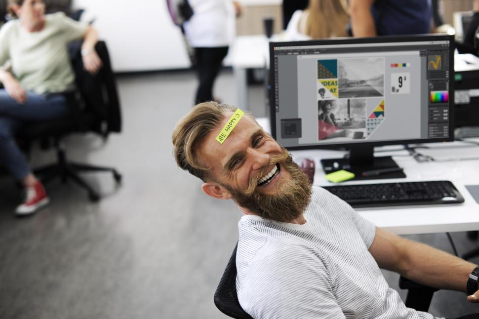 Free Image of A happy employee lying in the chair with a sticky note on his fo 