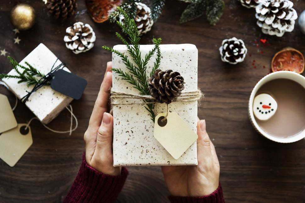 Free Image of Over the dead view of hands holding a Christmas gift box 