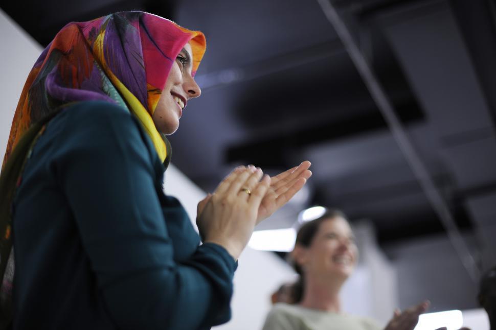 Free Image of A young woman wearing headscarf clapping 