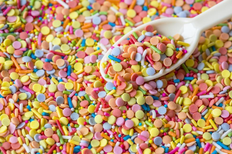 Free Image of Close of a spoonful of colorful candy balls and sprinkles 