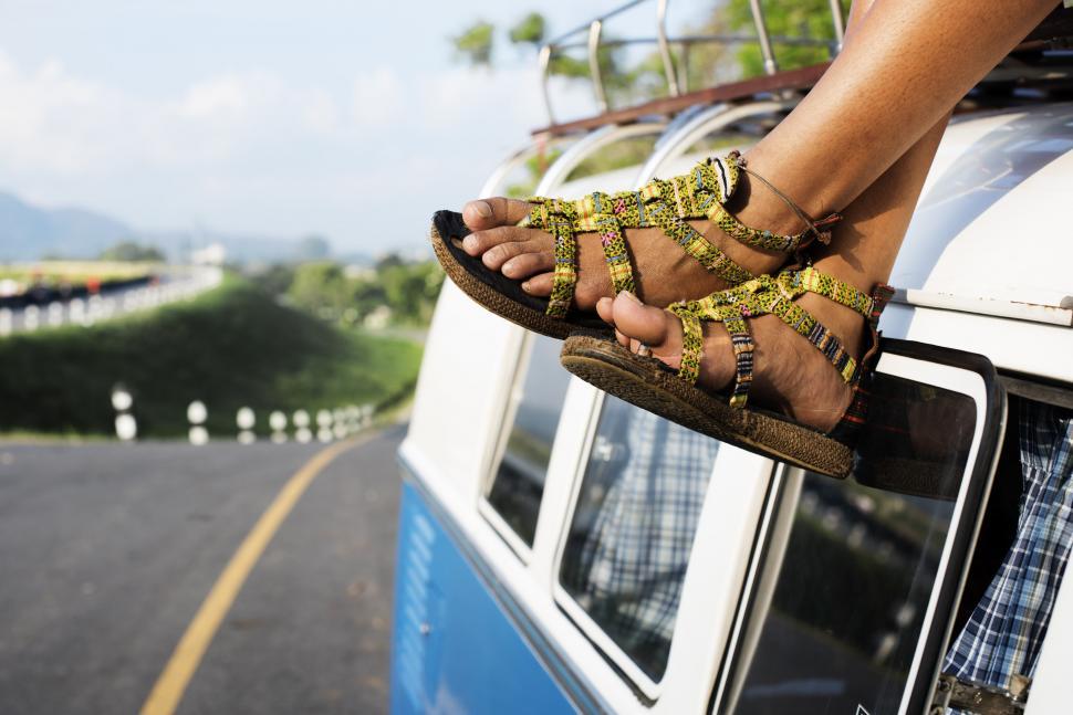 Free Image of Close up of a woman s feet hanging on the rooftop on a van 