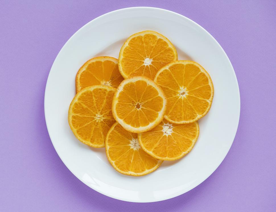 Free Image of Flat lay of orange slices arranged on white plate 
