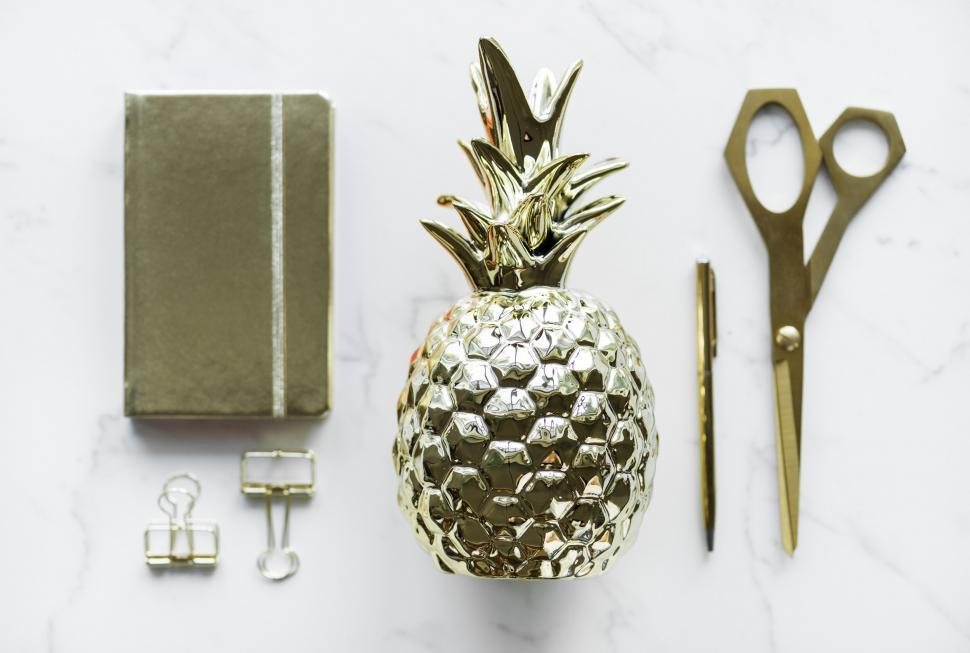 Free Image of Flat lay of a golden pineapple shaped paper weight with others s 