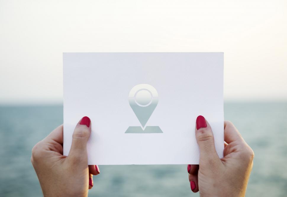 Free Image of A woman s hands holding a location sign shaped paper cut out tem 