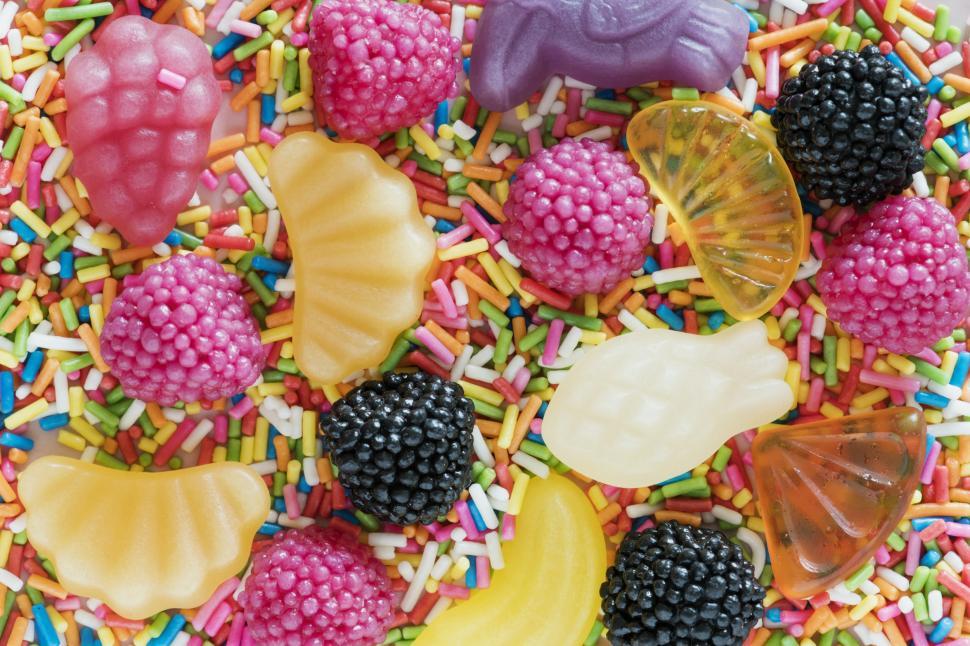 Free Image of Layer of hard fruit candies on rainbow candy sprinkles 