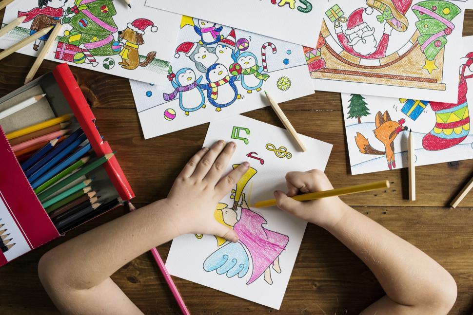 Free Image of A childs hands coloring a picture 
