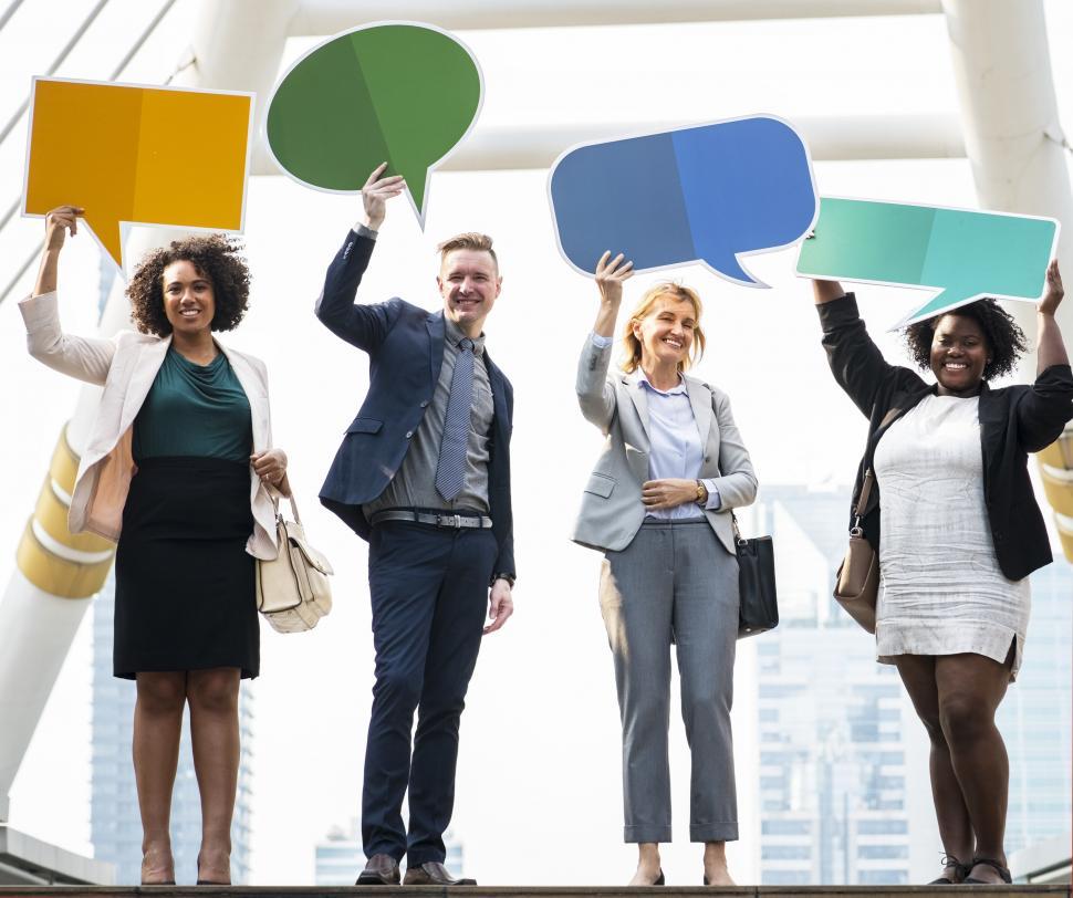 Download Free Stock Photo of A group of multiethnicity colleagues raising cardboard speech bu 