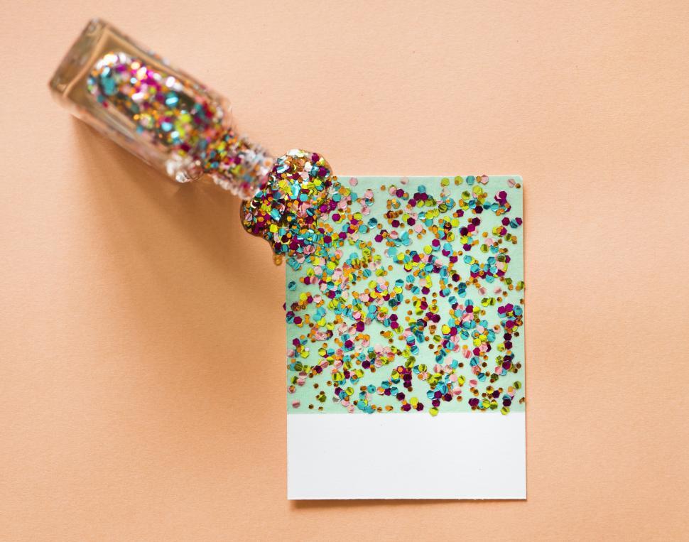 Free Image of Colorful hexagon shaped glitter sparkles poured from a bottle 