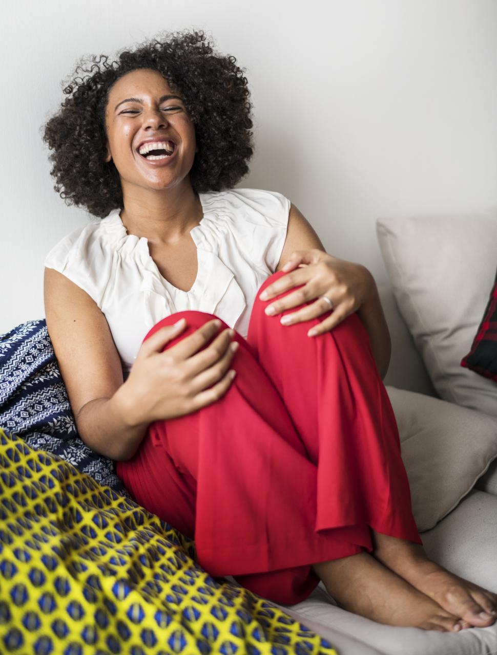 Free Image of A young African ethnicity woman with curly hair laughing 