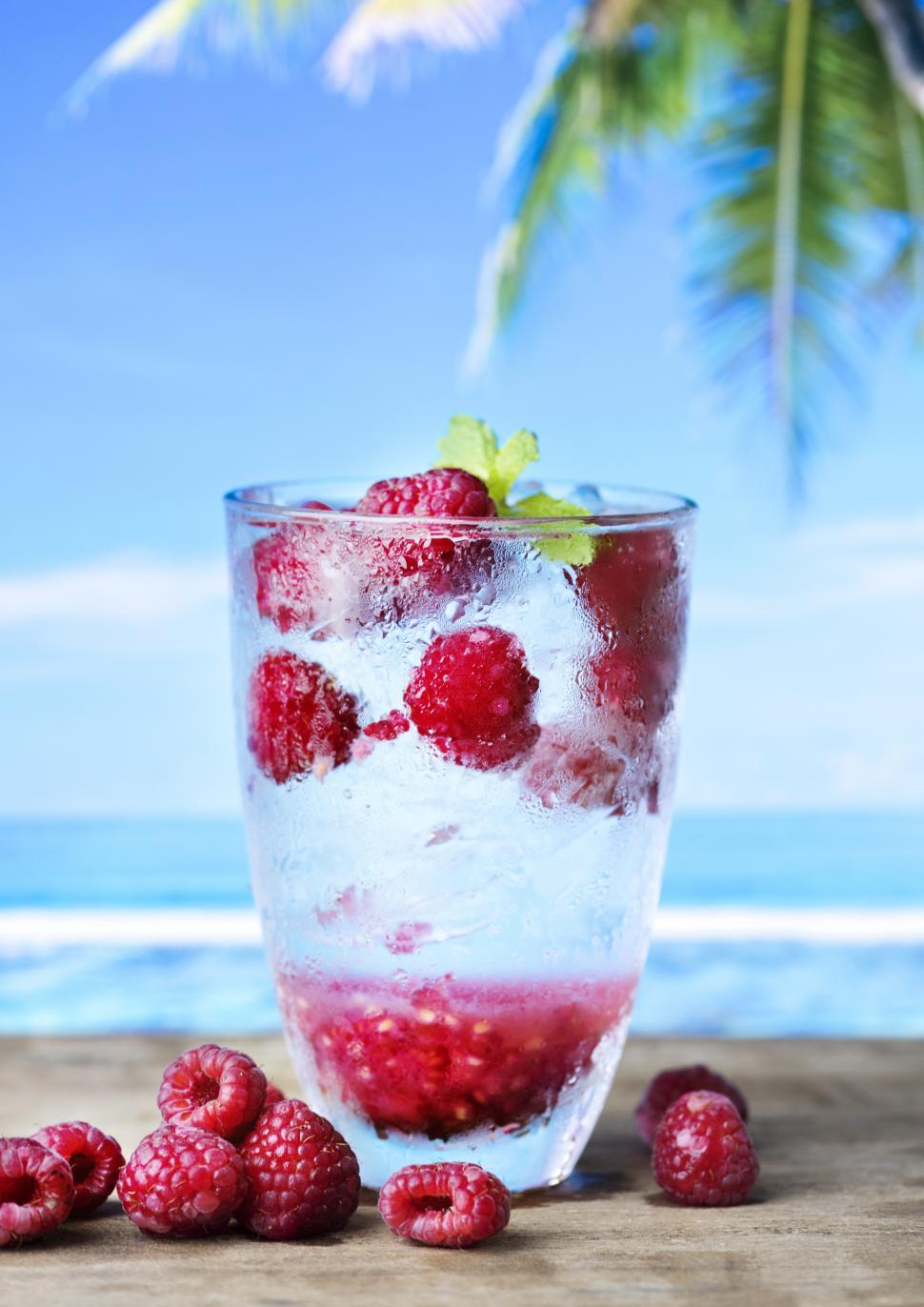 Free Image of Close up of a glass of chilled beverage garnished with raspberries 
