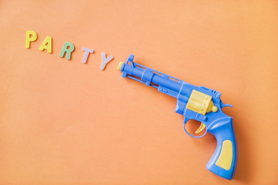Free Image of Flat lay of the word PARTY depicted as being fired from a toy gun 