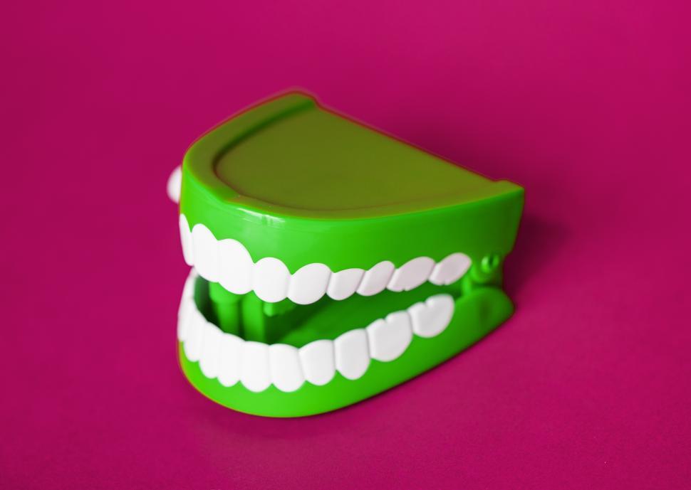 Free Image of A chattering teeth toy on magenta surface 