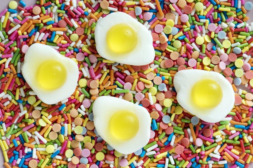 Free Image of Close up of colorful candy rainbow sprinkles with half fried egg shaped candies 