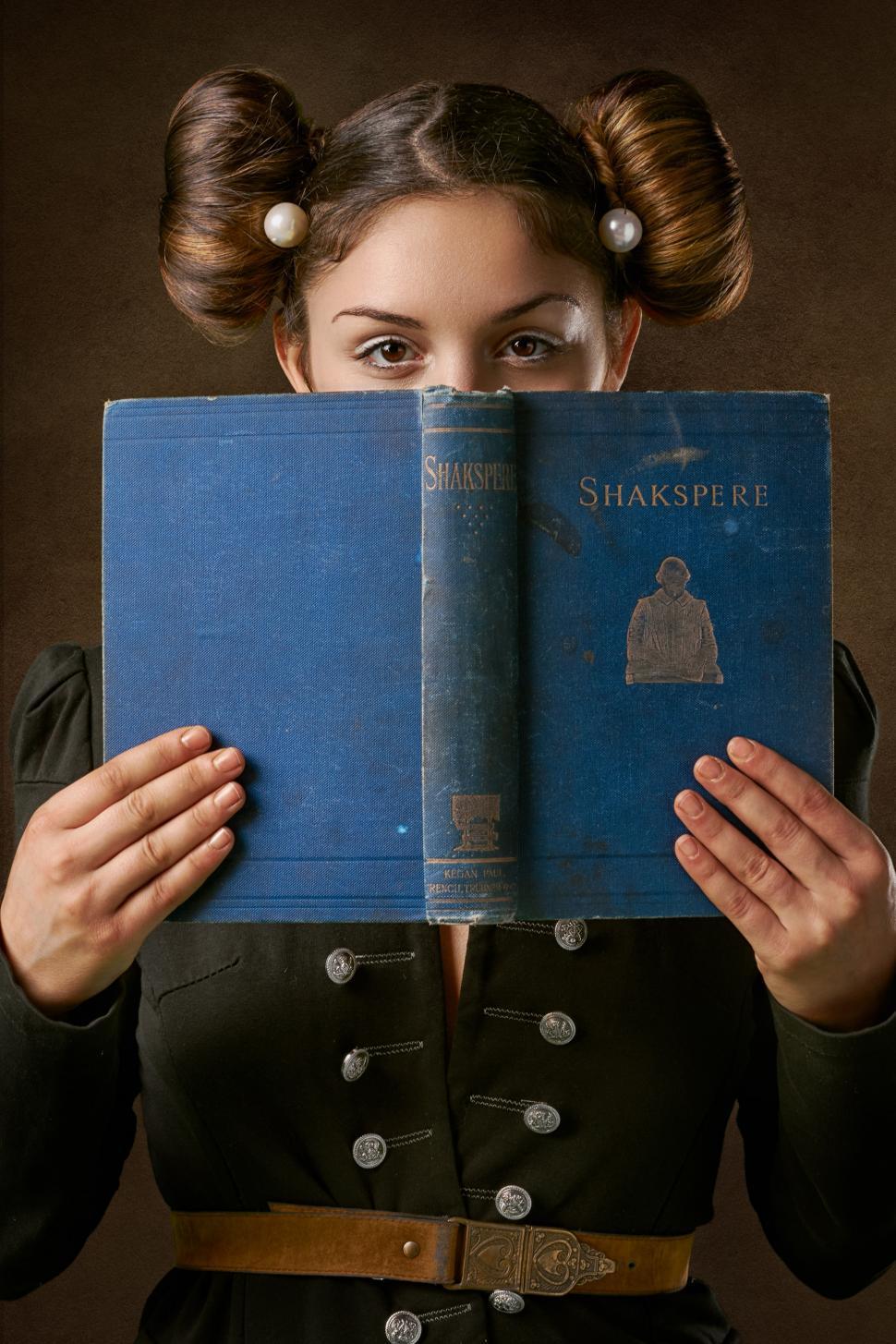 Free Image of Girl Smiling Behind a Book  