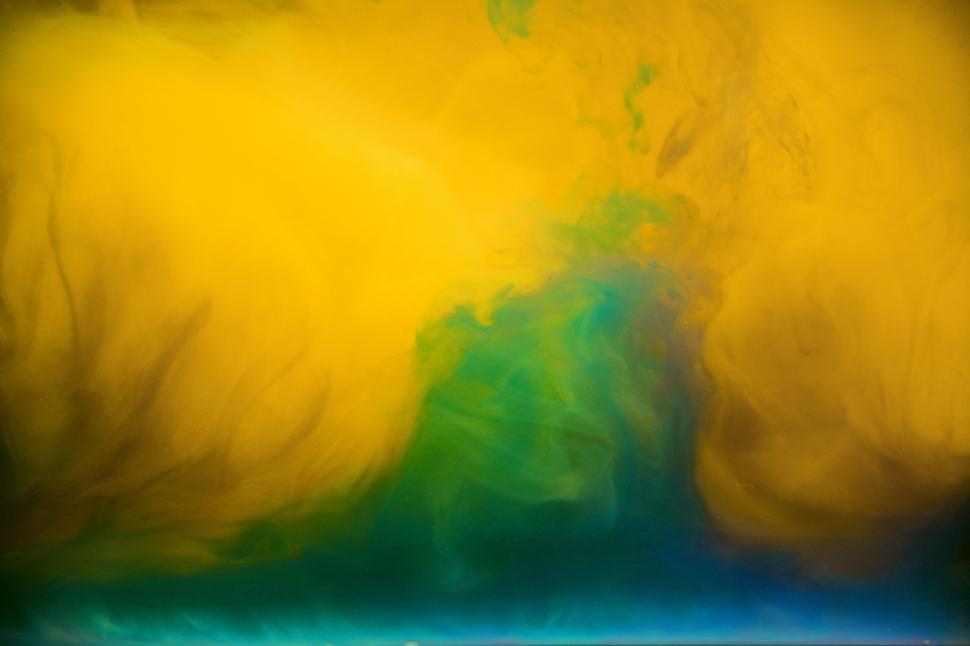Free Image of An abstract pattern of green and yellow ink swirling in water 