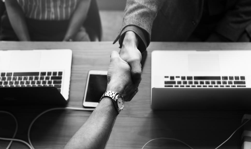 Free Image of Two business people shake hands - black and white 