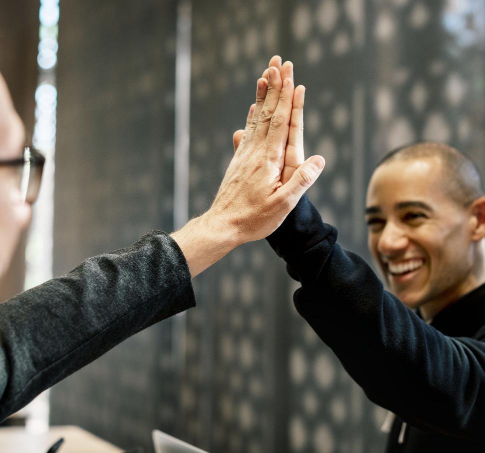 Free Image of Two men giving high five in the office 