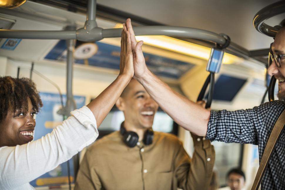Free Image of Coworkers giving high five in the train 