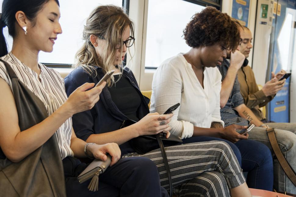 Free Image of People on the train, looking at their mobile phones 