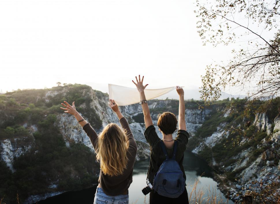 Free Image of Two young caucasian female hikers with hands up 