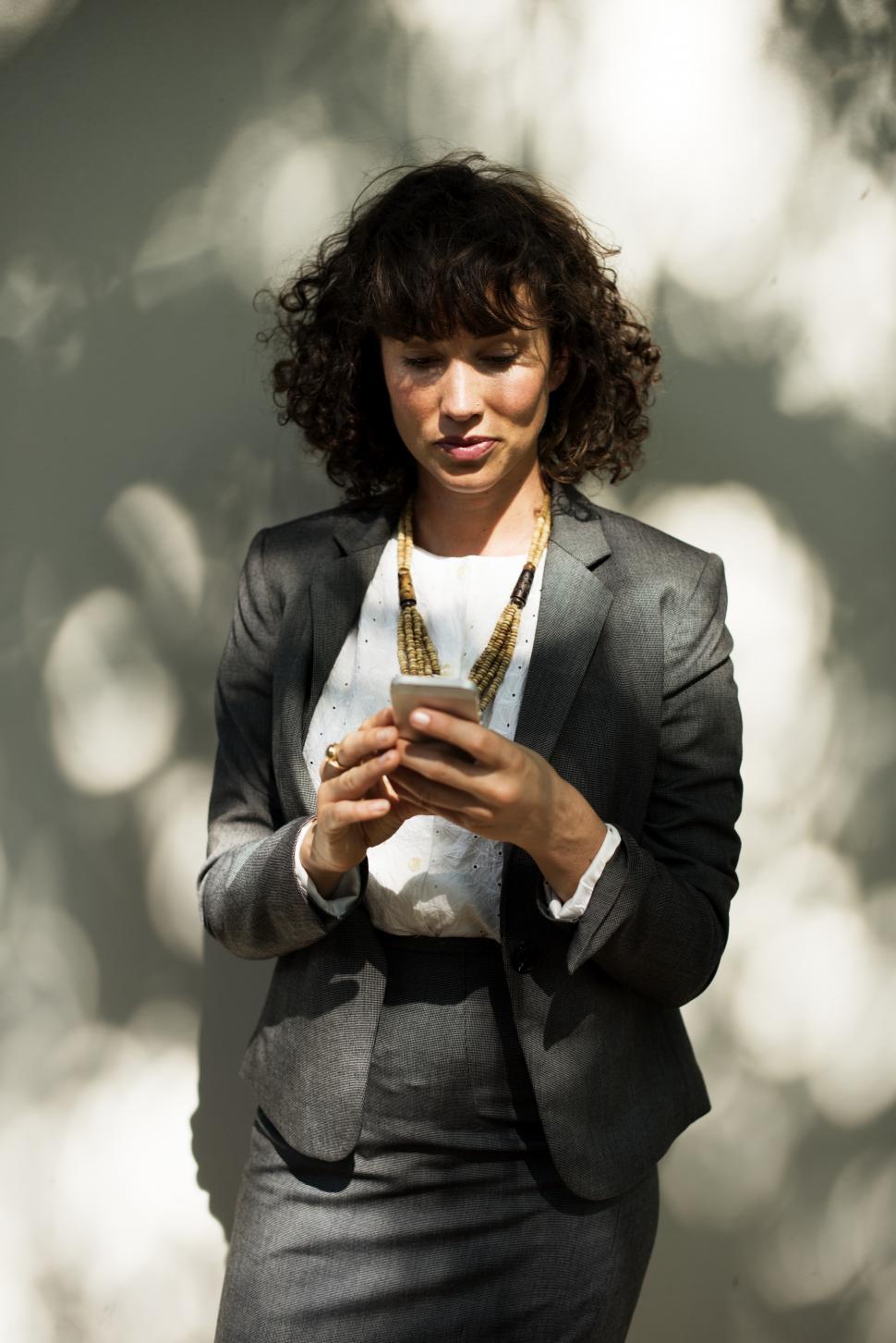 Free Image of A young caucasian woman looking at her mobile phone 